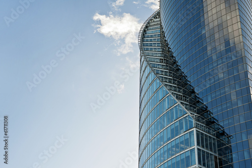 Curves of modern glass building on a blue sky background