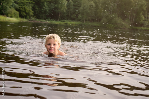 Fototapeta Naklejka Na Ścianę i Meble -  Boy swimming in a lake late afternoon