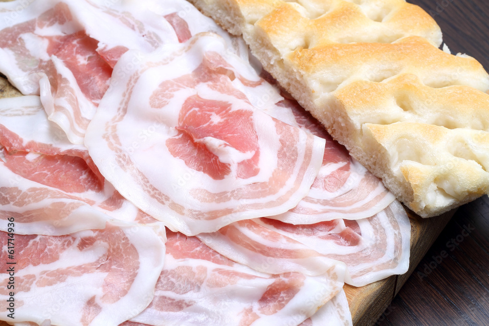 Bacon slices with focaccia on wooden cutting board Bacon slices with focaccia on wooden cutting board