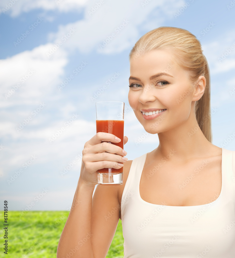 smiling woman holding glass of tomato juice smiling woman holding glass of tomato juice