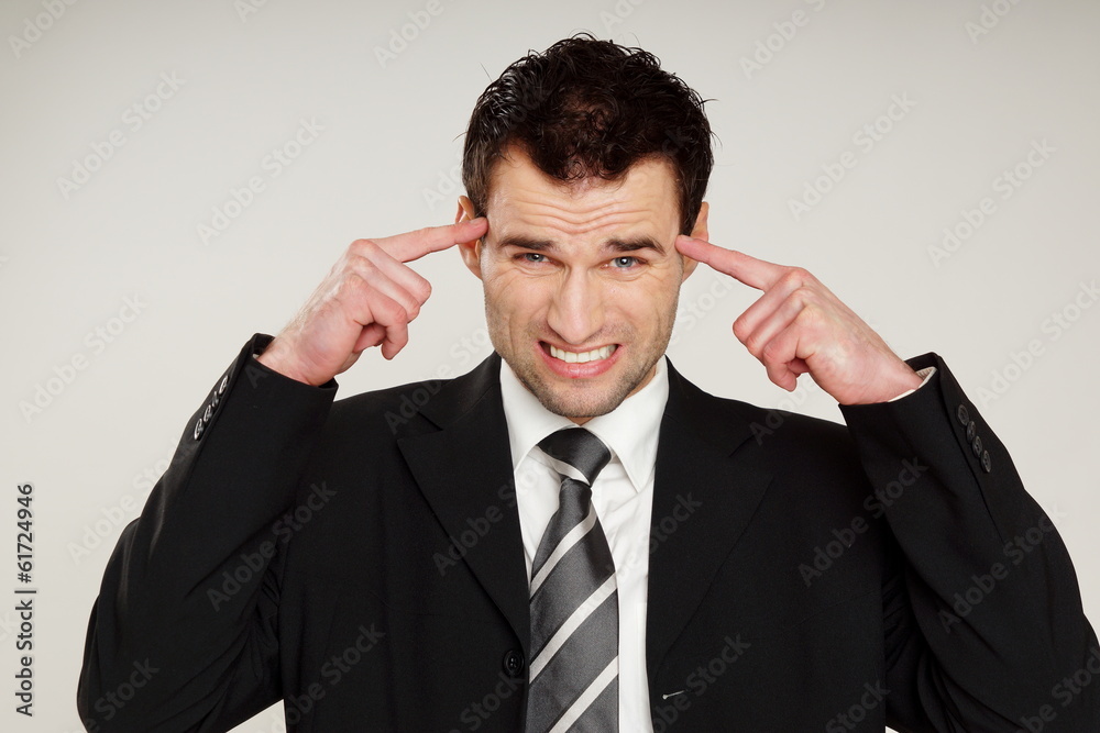 Angry handsome man in suit has a headache Angry handsome man in suit has a headache