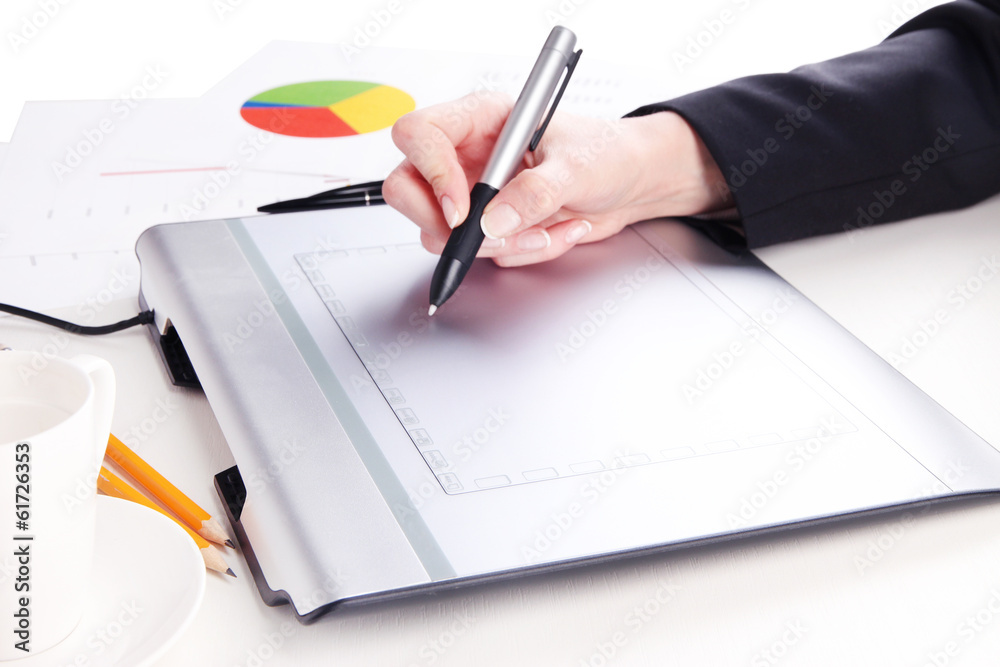 Female hand using graphics tablet on table close up Female hand using graphics tablet on table close up