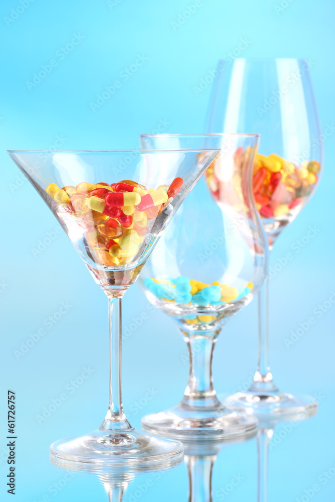 Goblets with pills on blue background Goblets with pills on blue background