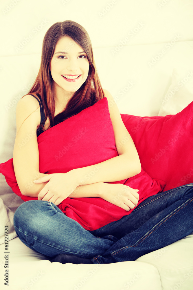 Young happy woman sitting on sofa Young happy woman sitting on sofa