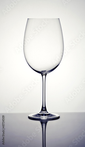 Empty wineglass on a reflective surface