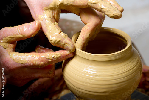 hands of a potter, creating an earthen jar