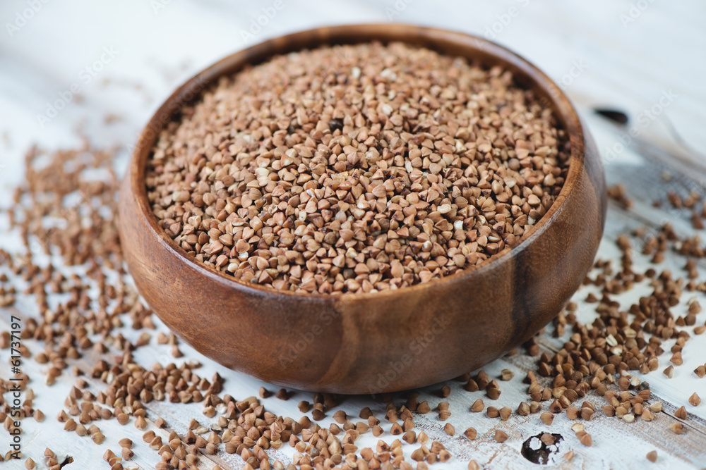 Raw buckwheat kernels in a wooden bowl, close-up