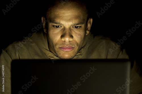 Man concentrating on his laptop late at night