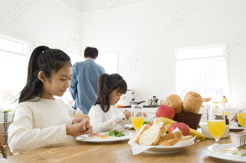 Two Japanese girls and fathers eating meals