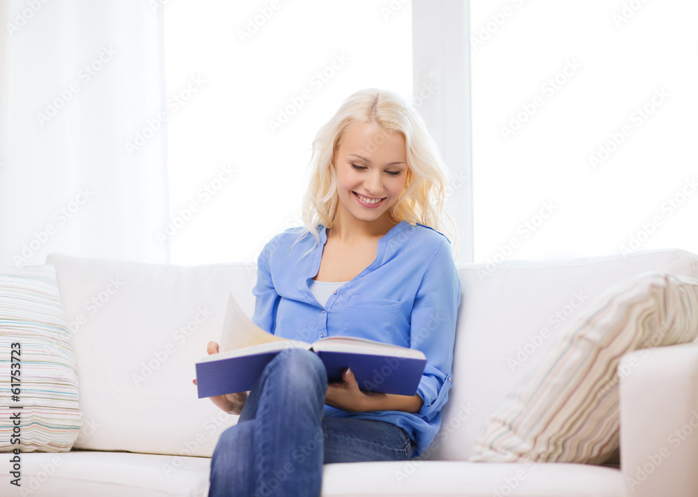 smiling woman reading book and sitting on couch smiling woman reading book and sitting on couch