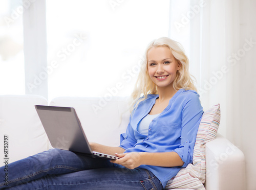 smiling woman with laptop computer at home