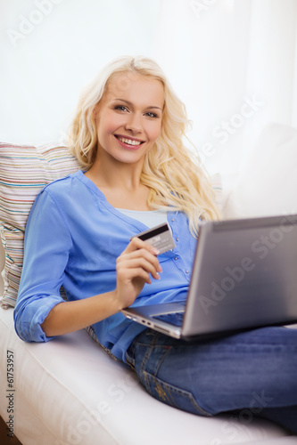 smiling woman with laptop computer and credit card