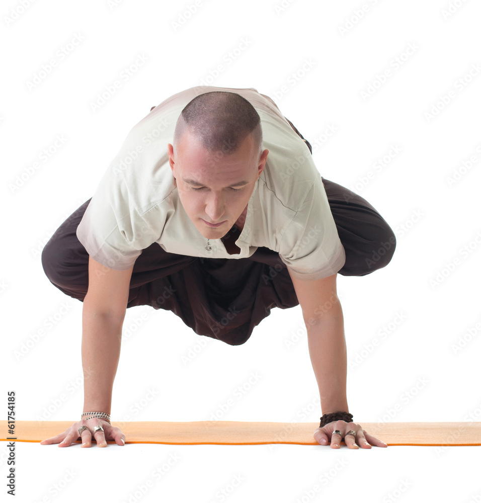 Meditator man doing yoga in studio