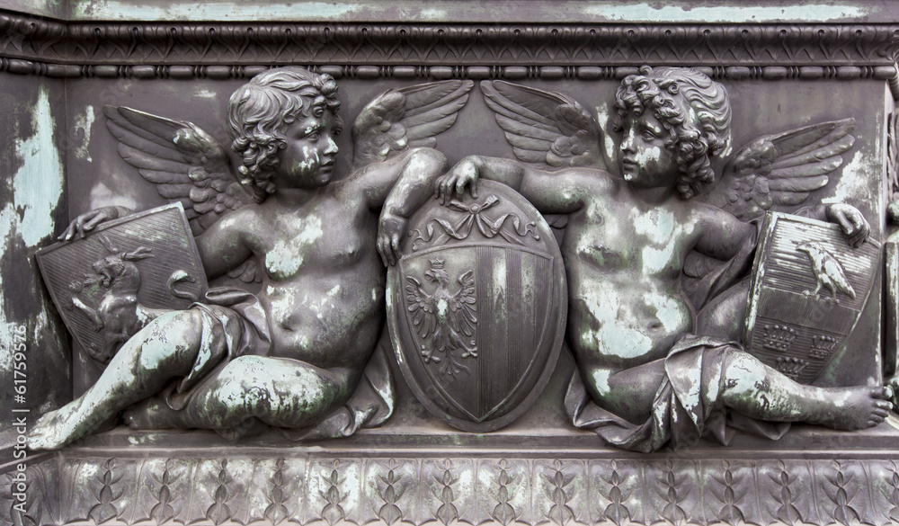 Obraz premium Bronze relief of cherubs holding shields