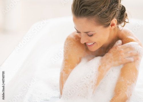 Relaxed young woman sitting in bathtub