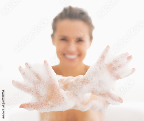 Closeup on young woman showing hands in foam photo