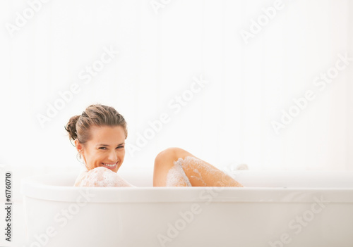 Carta da parati Happy young woman washing in bathtub