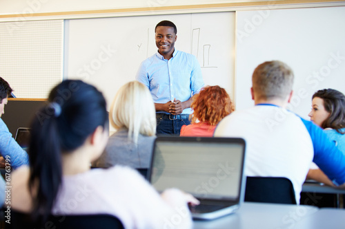 Male Tutor Teaching University Students In Classroom