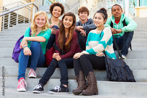 Portrait Of High School Students Sitting Outside Building photo