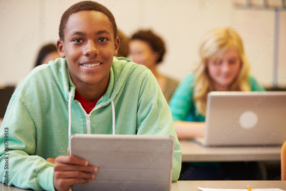 © Monkey Business - High School Student At Desk In Class Using Digital Tablet