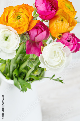 bouquet of white  pink and orange buttercups on wooden table