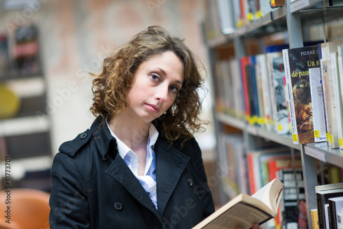 beautiful young woman reading books in public library