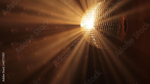 Shiny disco ball with golden reflection and rays in haze, HD 108