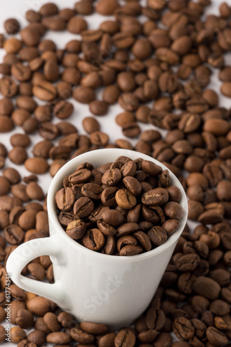 Roasted brown coffee beans in small espresso coffee cup
