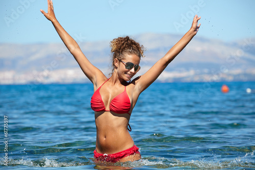 Beautiful bikini model splashing water