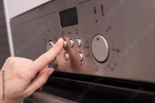 Girl's hand push the oven's button