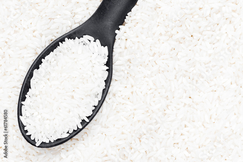 Spoon on a raw white rice grains background