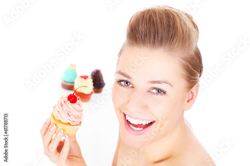 Happy woman eating cupcakes
