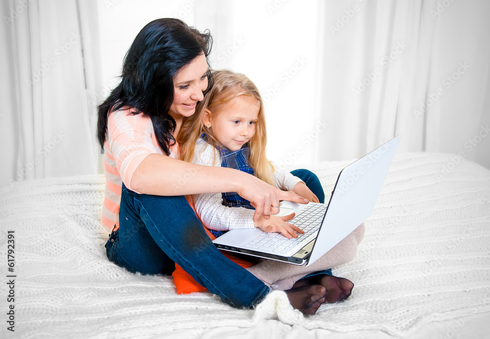 happy mother and daughter working on a laptop happy mother and daughter working on a laptop