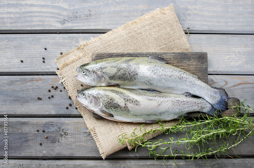 Two rainbow trouts on rustic wooden table photo