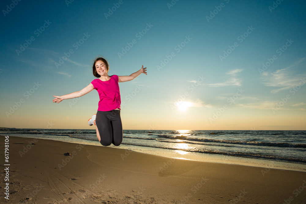 Teenage girl running, jumping on beach Teenage girl running, jumping on beach