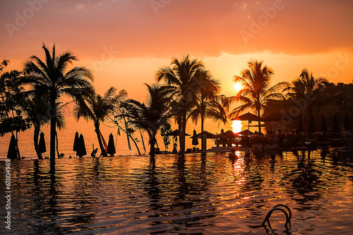 Sunset over swimming pool at a tropical resort