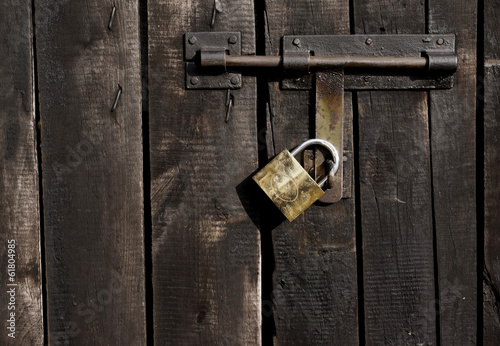 latch with padlock on the door made ​​of wooden black boards