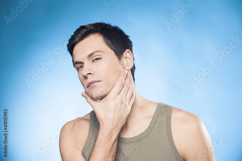 Man in front of mirror looking at his chin chacking is he well-s photo