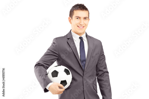 Fototapeta Naklejka Na Ścianę i Meble -  Young handsome businessman holding a football
