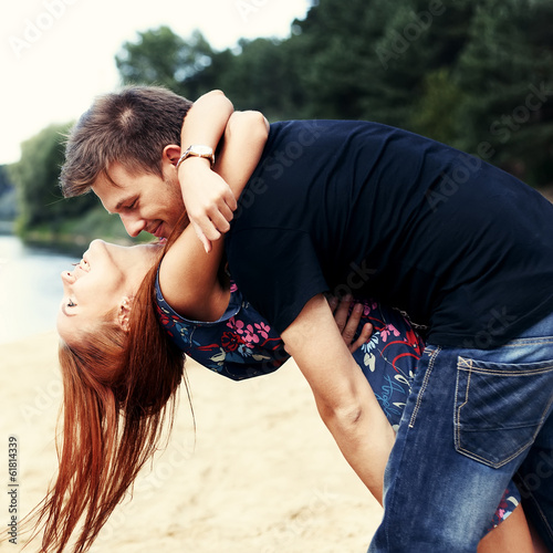 Beautiful cute couple on the beach near the water hugging