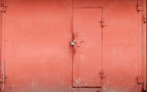 Red metal garage wall with locked gate. Background texture