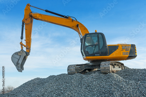 exkavator on big pile of gravel photo