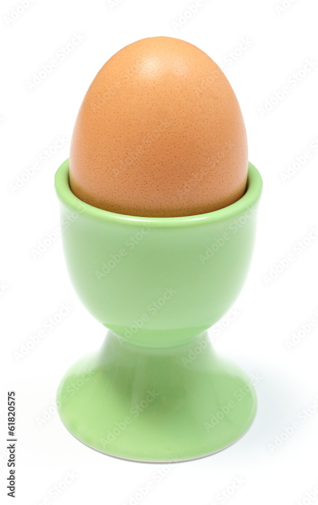 Closeup of boiled egg in green cup. White background Closeup of boiled egg in green cup. White background