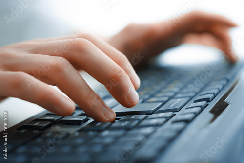 Close-up of typing female hands on keyboard photo