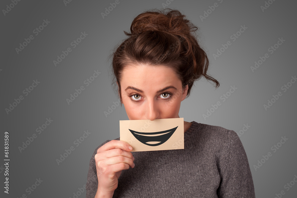 Happy pretty woman holding card with funny smiley Happy pretty woman holding card with funny smiley