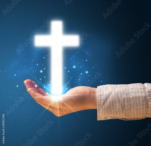 Glowing cross in the hand of a woman