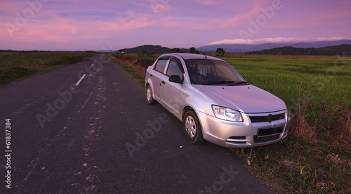 Car parked on roadside in a rural area at sunset © macbrianmun