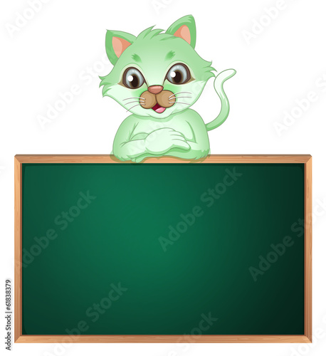 A green cat leaning above the blackboard