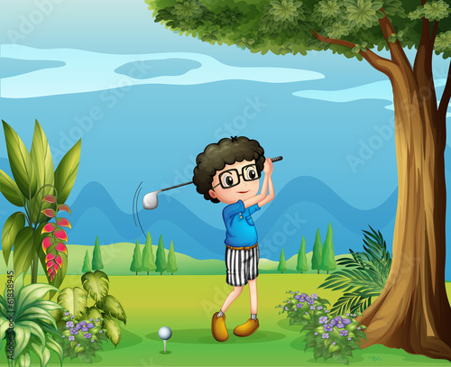 A boy playing golf near the tree