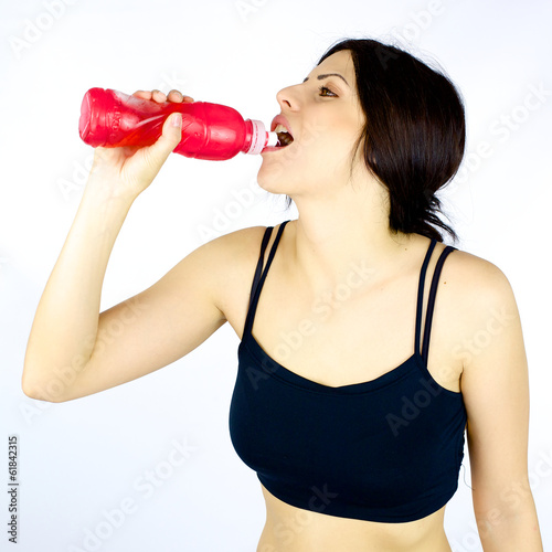 Sporty young woman drinking after fitness